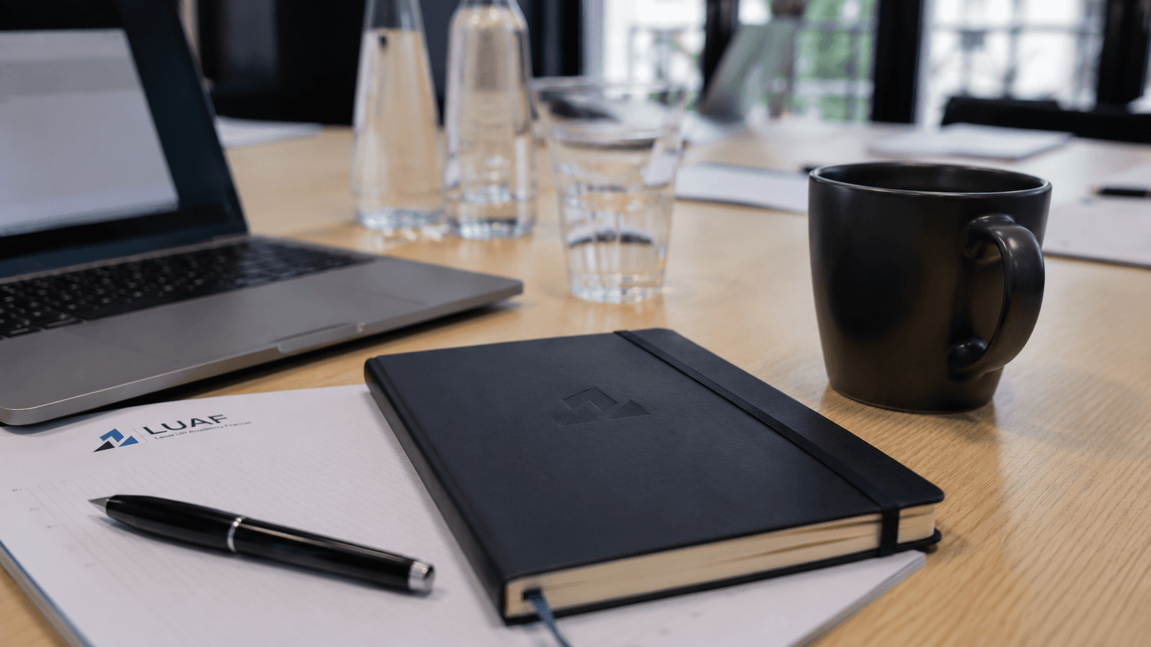 Un cahier et des documents LUAF sur une table de travail